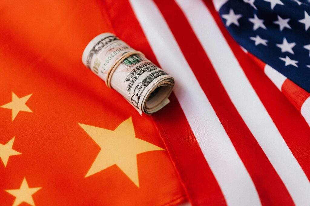 From above of roll of dollar bills tied with rubber band on bright American flag with stars and stripes symbolizing unity and peace